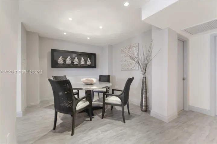 Neutral-toned space featuring recessed ceiling lighting, smooth-finish walls, and light wood-finish flooring