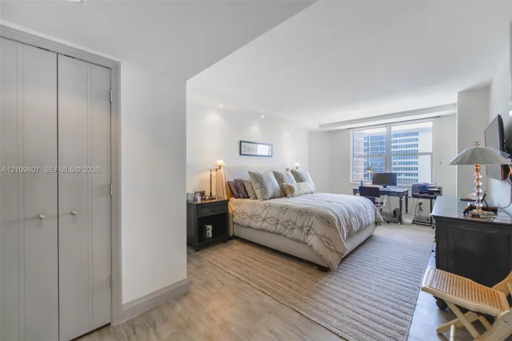 Spacious room featuring wood-finish flooring, recessed lighting, and a multi-pane window