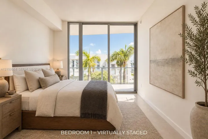 Floor-to-ceiling glass sliding doors, private balcony, neutral wall finishes, and light-toned hard-surface flooring