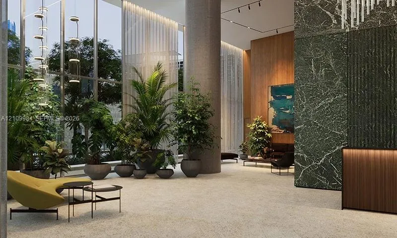 Floor-to-ceiling glass windows, stone-finish flooring, full-height decorative stone wall, wood-finish reception desk, and architectural track lighting