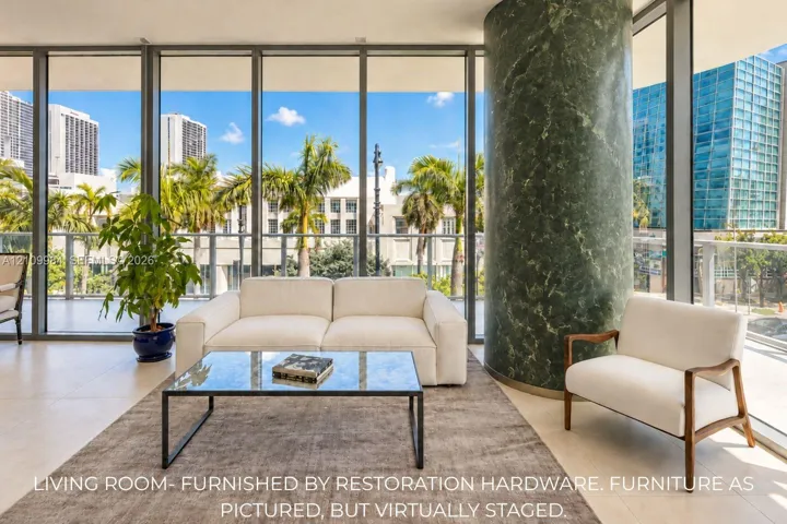 Floor-to-ceiling glass wall, expansive natural light, and structural stone-finished cylindrical column