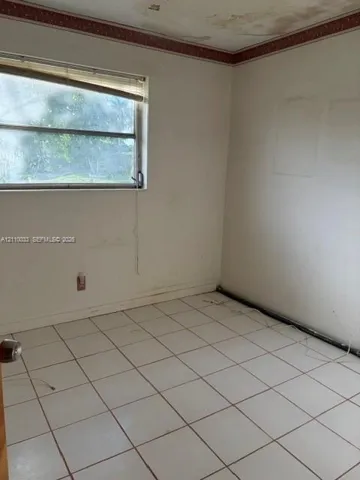 Interior space featuring white square tile flooring and a horizontal sliding window