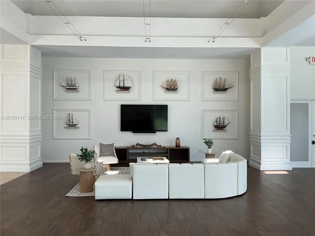 Tray ceiling with recessed lighting, prominent architectural columns with millwork, and dark wood-finish flooring