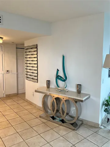 Neutral-toned tile flooring and wall-mounted decorative mirrored glass panel