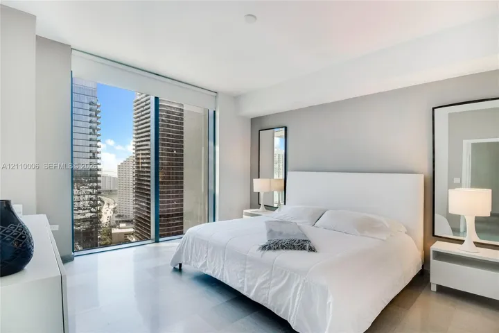 Floor-to-ceiling windows, polished stone flooring, and urban skyline exterior