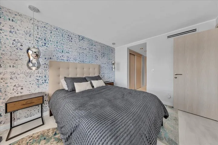 Patterned accent wallpaper, metallic pendant lighting, wood-finish interior door, and integrated climate control system