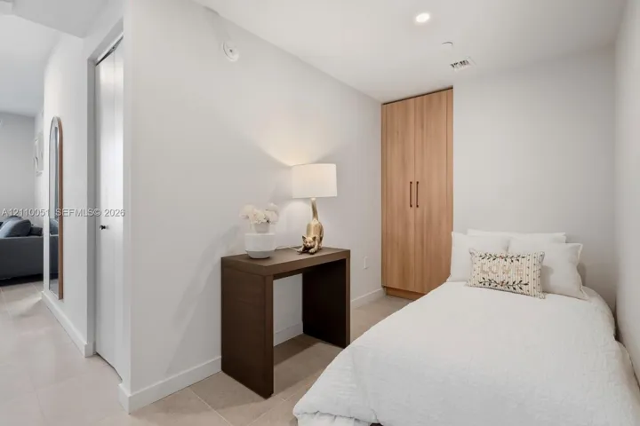 Built-in floor-to-ceiling wood-finish cabinetry, recessed ceiling lighting, and tile flooring