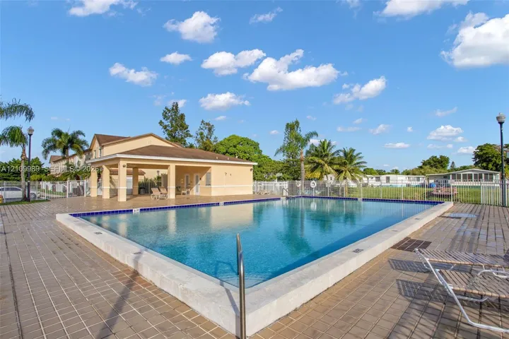 Outdoor swimming pool with a concrete perimeter and covered poolside cabana