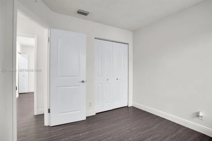 Interior space featuring wood-finish flooring, two-panel interior doors, and a double-door closet