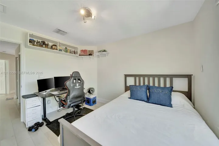 Neutral-toned room featuring light-colored flooring and built-in white corner shelving