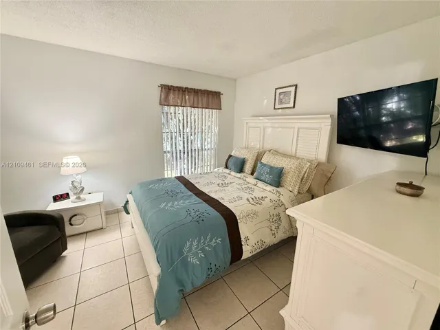 Neutral-toned tile flooring and vertical window blinds