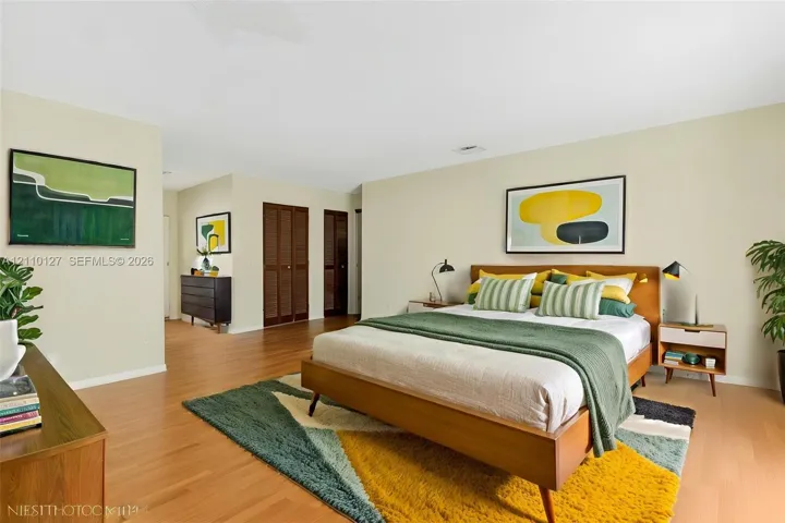 Interior room featuring wood-finish flooring and double-door wood-slat closets