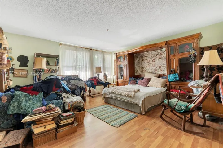 Wood-finish flooring and expansive floor-to-ceiling built-in cabinetry featuring integrated shelving and storage units