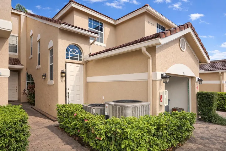 CBS - Stucco exterior featuring arched accent windows, tile roofing, an integrated garage, and paver walkway