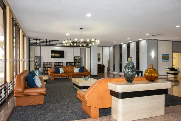 Spacious common area featuring recessed lighting, a statement chandelier, expansive floor-to-ceiling windows, and decorative room dividers