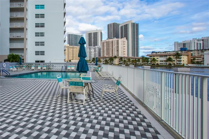 Pool deck featuring patterned paver surfacing, rectangular swimming pool, and metal perimeter railing
