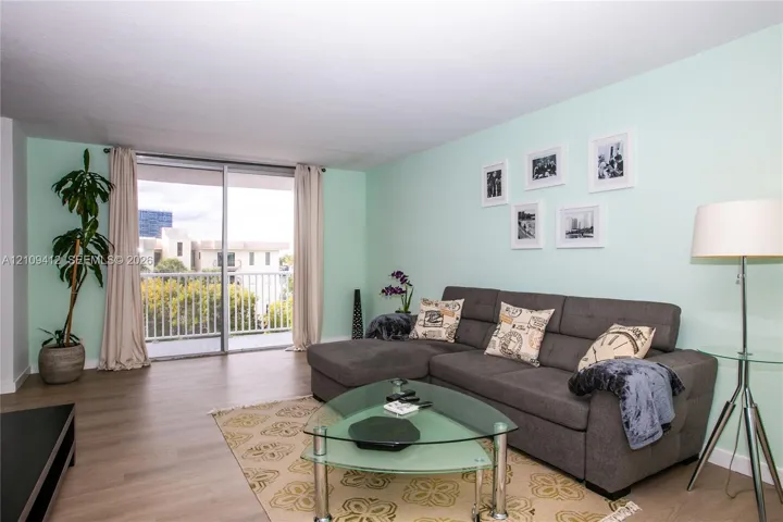 Living area featuring wood-finish flooring and sliding glass doors with access to an exterior balcony