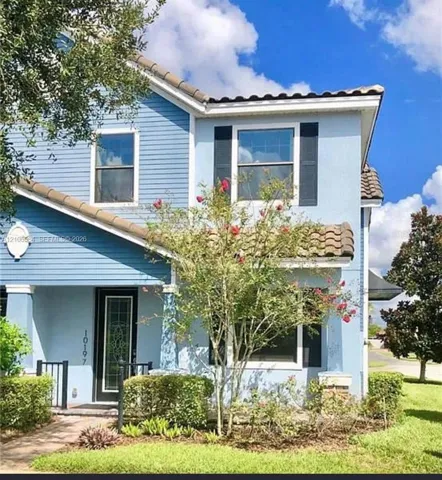 Two-story exterior featuring a mix of horizontal lap siding and smooth stucco finish, clay tile roof sections, decorative window shutters, and a glass-paneled entry door