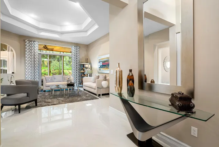 Polished tile flooring, tray ceilings with recessed lighting, and large glass sliding doors providing natural light