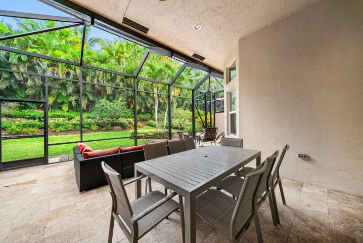 Screened-in lanai featuring stone-finish flooring, recessed lighting, and a metal enclosure