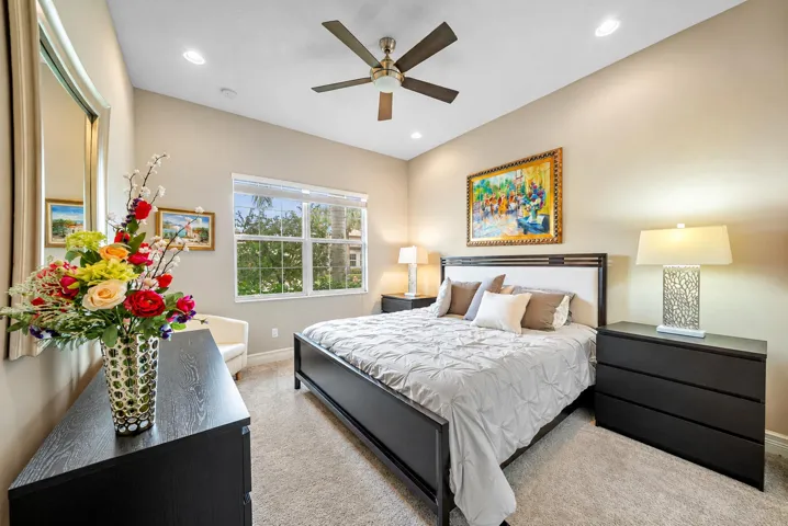 Neutral interior space featuring high ceilings, recessed lighting, a multi-blade ceiling fan, and a large grid-patterned window