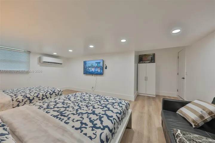 Interior space featuring wood-finish flooring, recessed lighting, and a wall-mounted ductless climate control unit