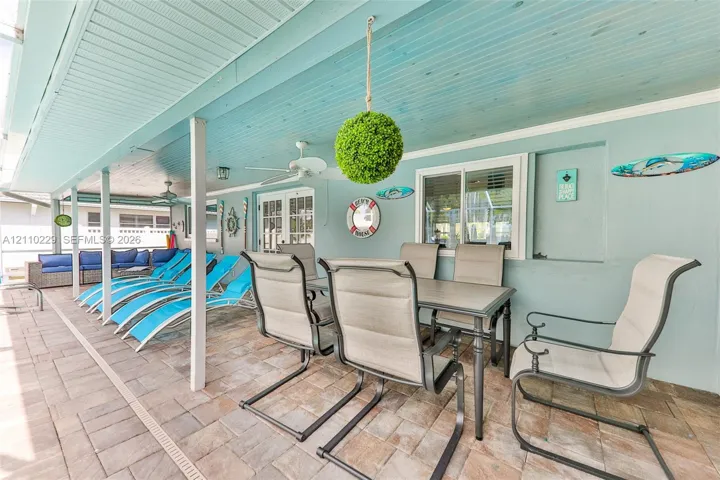 Covered patio featuring a paver floor, beaded wood-finish ceiling, and integrated ceiling fans