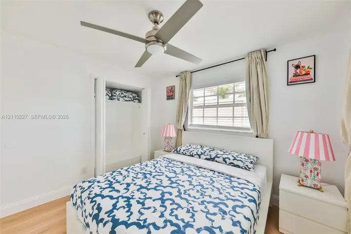 Wood-finish flooring, ceiling fan with integrated lighting, multi-pane window, and built-in closet