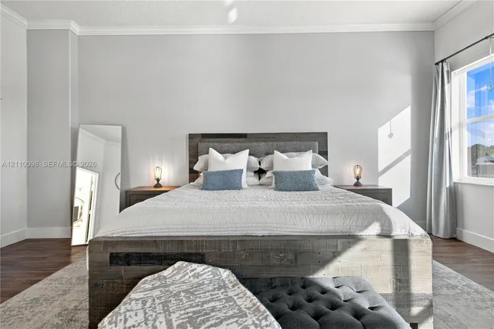 Neutral-toned wall paint, wood-finish flooring, and crown molding