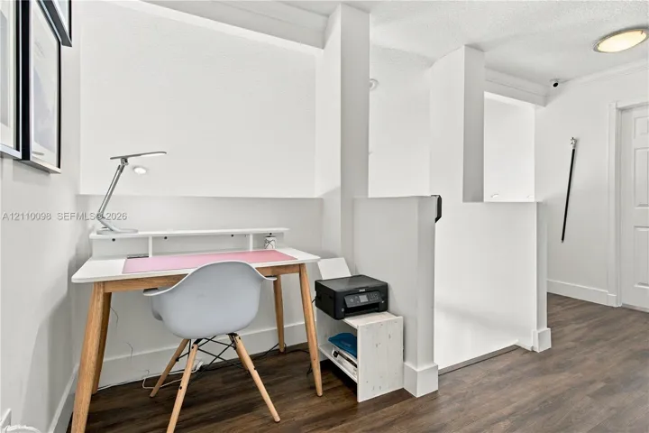 Alcove featuring wood-finish flooring, white walls, and a low-profile pony wall partition