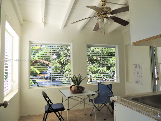 Exposed white-painted ceiling beams, ceiling fan with light fixture, tile flooring, and windows with horizontal blinds
