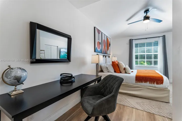 Wood-finish flooring, ceiling fan with integrated lighting, and window with muntins