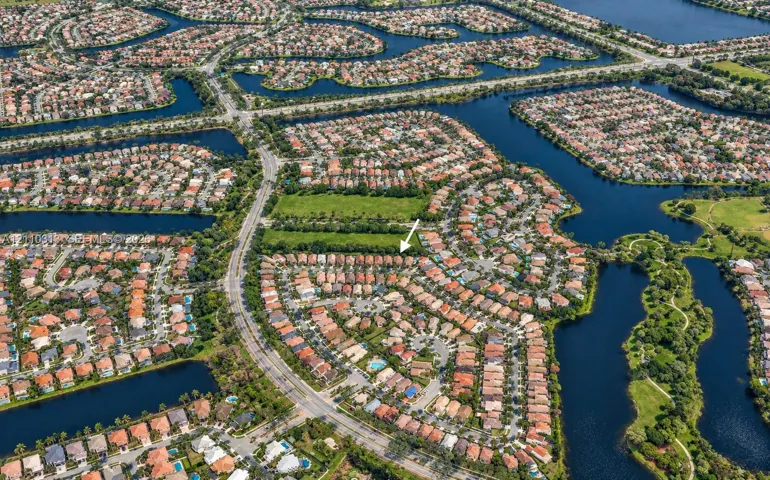 Aerial perspective of a residential community featuring winding waterways and structured suburban layout