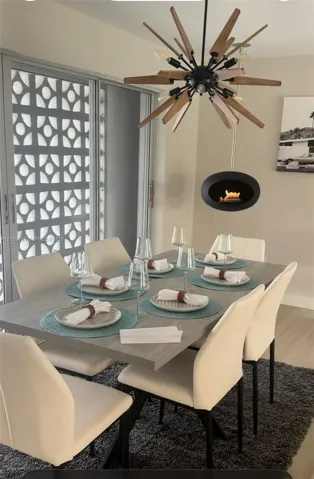 Mid-century modern sunburst chandelier, matte black suspended oval fireplace, and decorative geometric concrete privacy screen