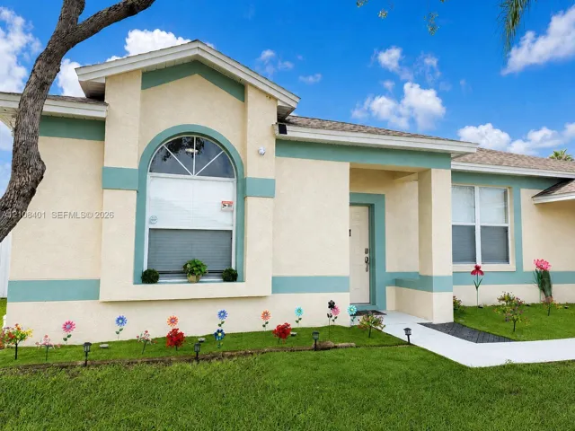 Stucco exterior featuring a prominent arched window, recessed entryway, and a covered porch