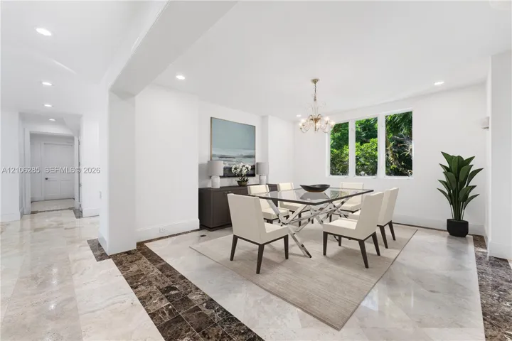 Dining area featuring recessed lighting, multi-paned windows, and stone tile flooring with a decorative dark stone border