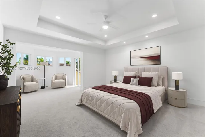 Tray ceiling with recessed lighting, central ceiling fan, neutral carpeting, and multi-pane windows