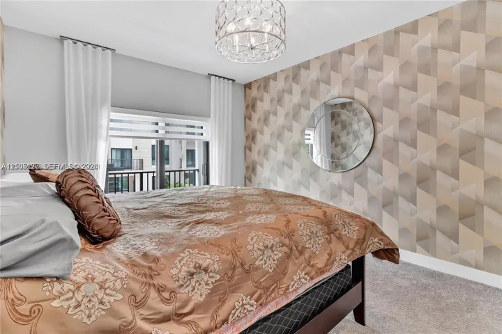 Geometric patterned wallpaper, circular wall-mounted mirror, drum-style crystal pendant light, and horizontal window blinds