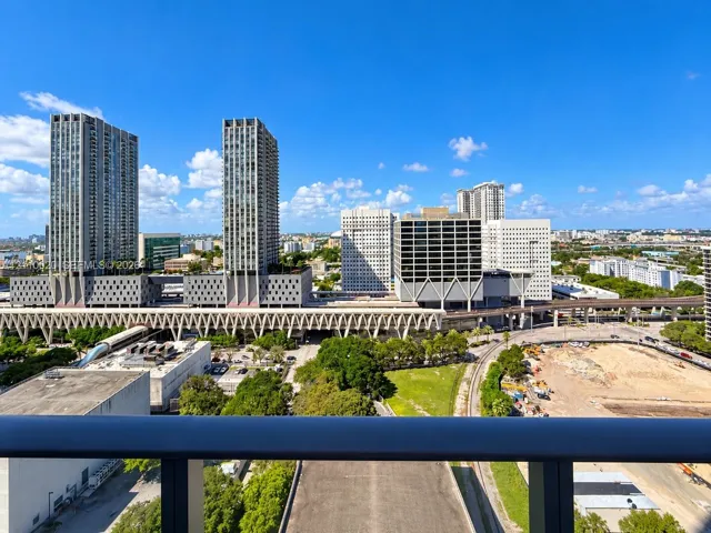 Elevated balcony with a dark metal railing featuring an expansive metropolitan skyline backdrop