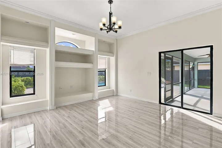 Interior space featuring wood-finish flooring, built-in recessed cabinetry, a five-light chandelier, and floor-to-ceiling sliding glass doors
