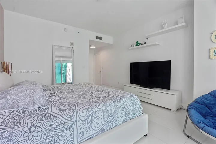 White stone-finish flooring, dual wall-mounted floating shelves, and a solid-core interior door