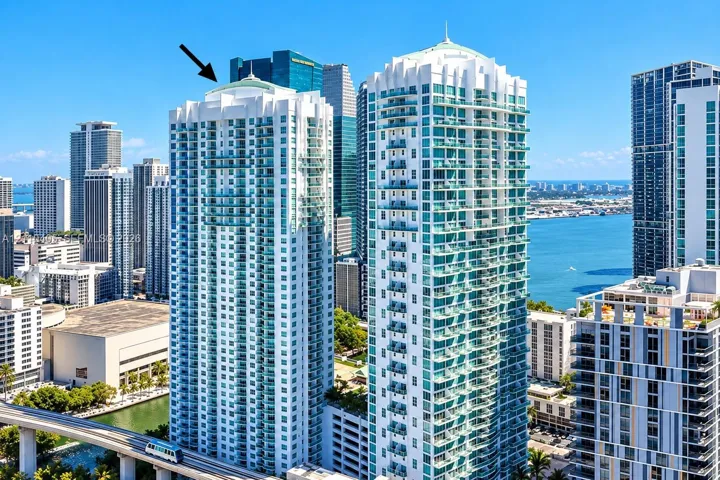 High-rise building featuring a white concrete facade, glass-enclosed balconies, and a dome-style architectural roof design
