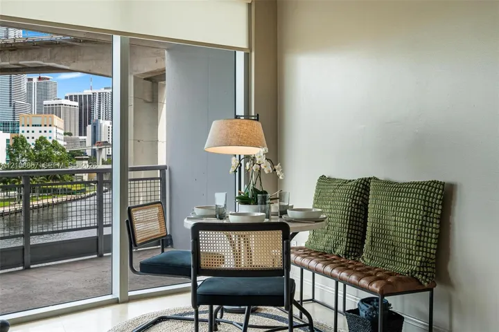 Floor-to-ceiling windows, retractable solar shade, and private balcony with metal railing, showcasing an urban cityscape