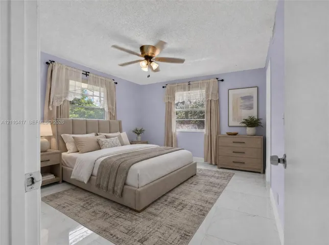 Bedroom featuring polished stone-finish flooring and a central ceiling fan with integrated lighting