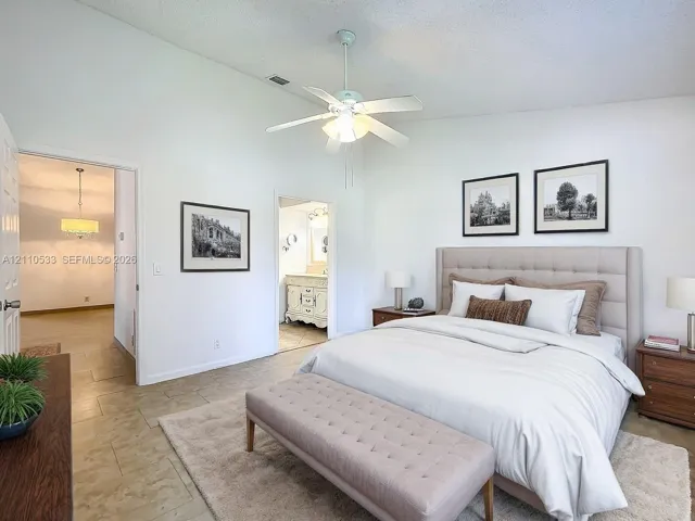 Vaulted ceilings, large-format tile flooring, and a central ceiling fan
