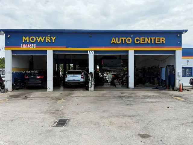 Commercial facility featuring three service bays, a concrete exterior apron, and prominent street-facing signage