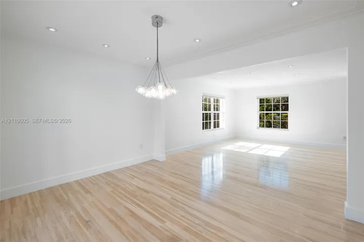 Bright interior featuring wood-finish flooring, multi-pane windows, a contemporary multi-globe pendant light fixture, and recessed lighting
