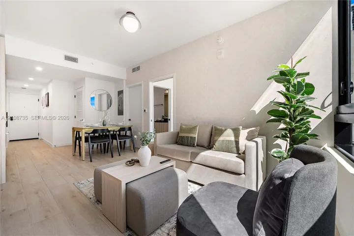 Open-concept living space featuring wood-finish flooring, recessed lighting, and large window