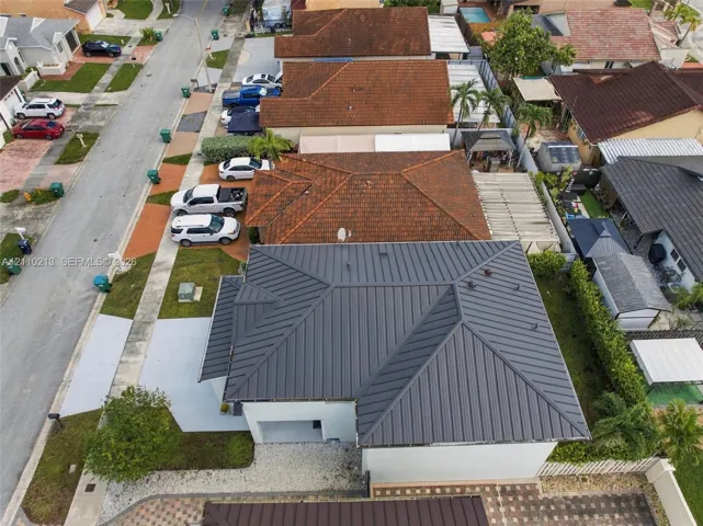 Standing seam metal roof, paved driveway, and side-entry garage
