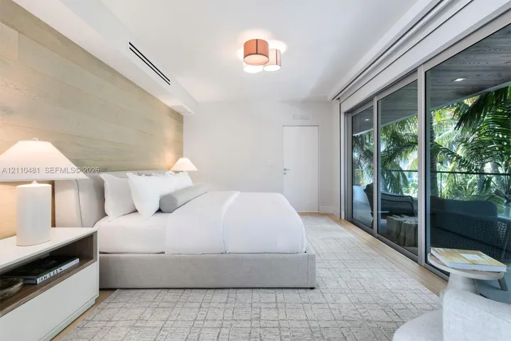 Wood-finish wall paneling, floor-to-ceiling sliding glass doors, recessed lighting, and flush-mount ceiling fixture